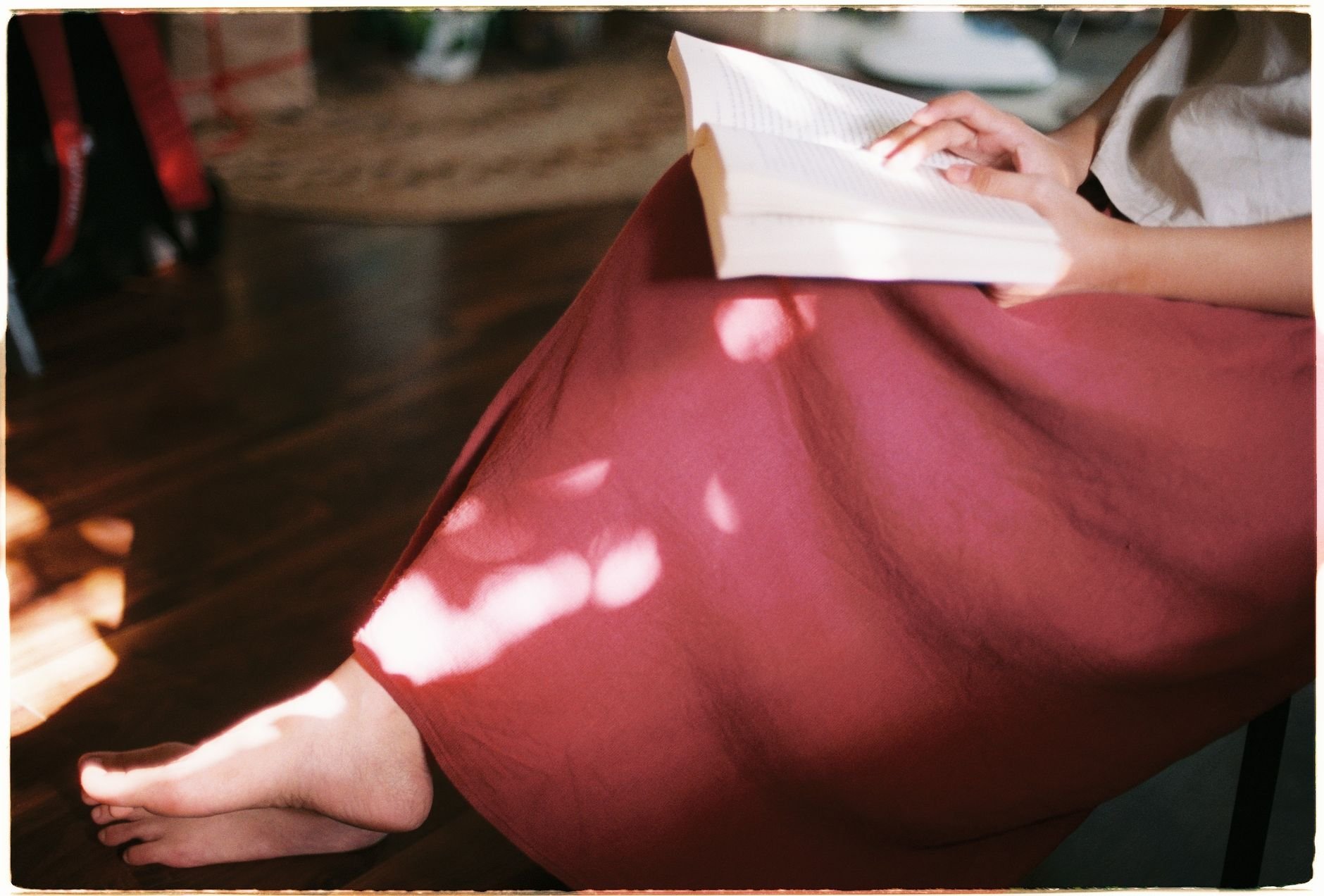 Woman enjoying a peaceful afternoon reading in a cozy, sunlit room.